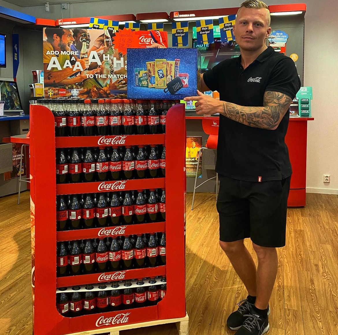 Medarbetare vid en stor dryckesdisplay med läsk i butiken